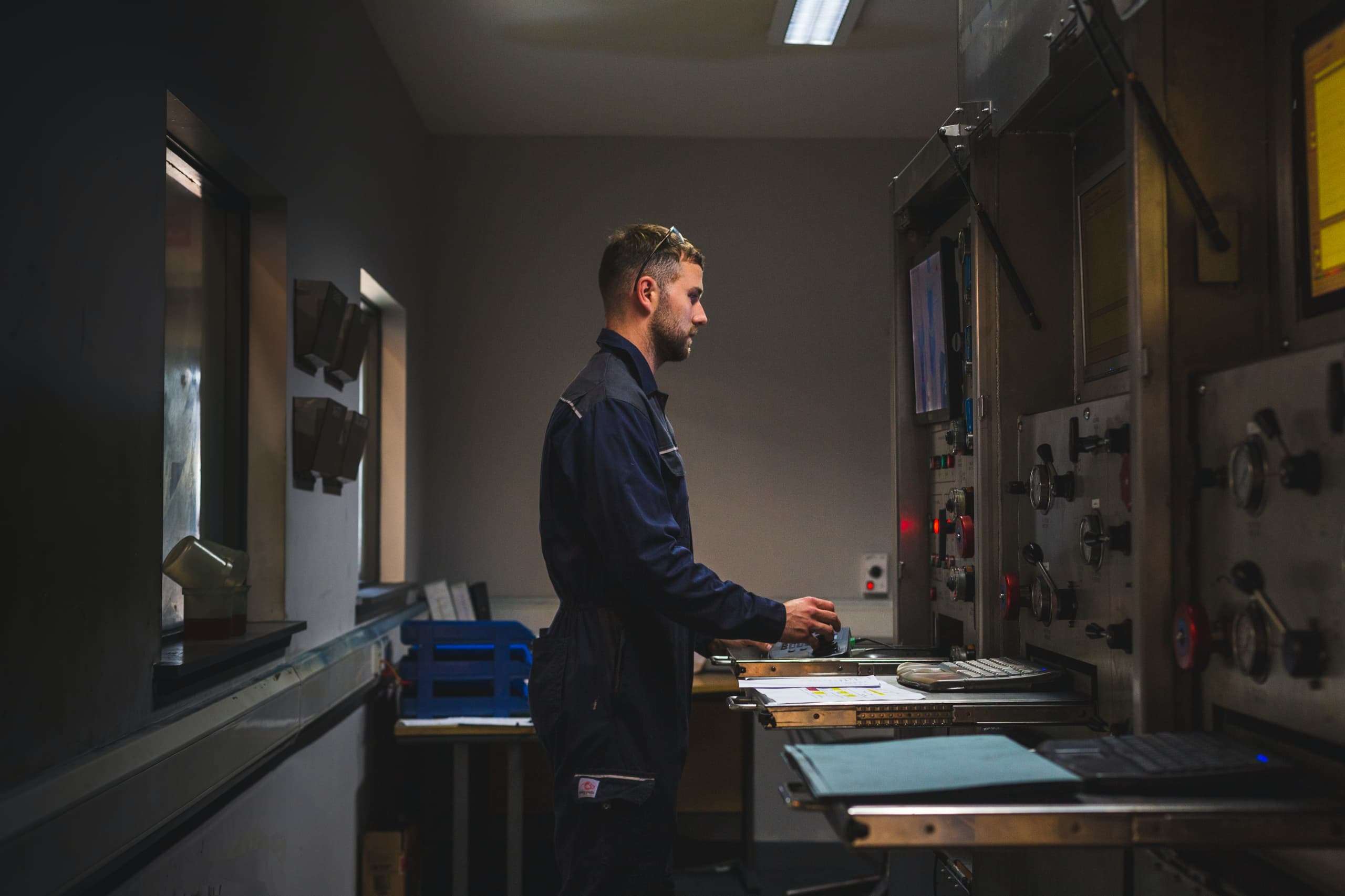 Hunting employee standing in boiler suit in control room