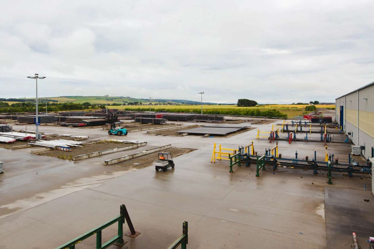Facility yard with pipes and forklifts