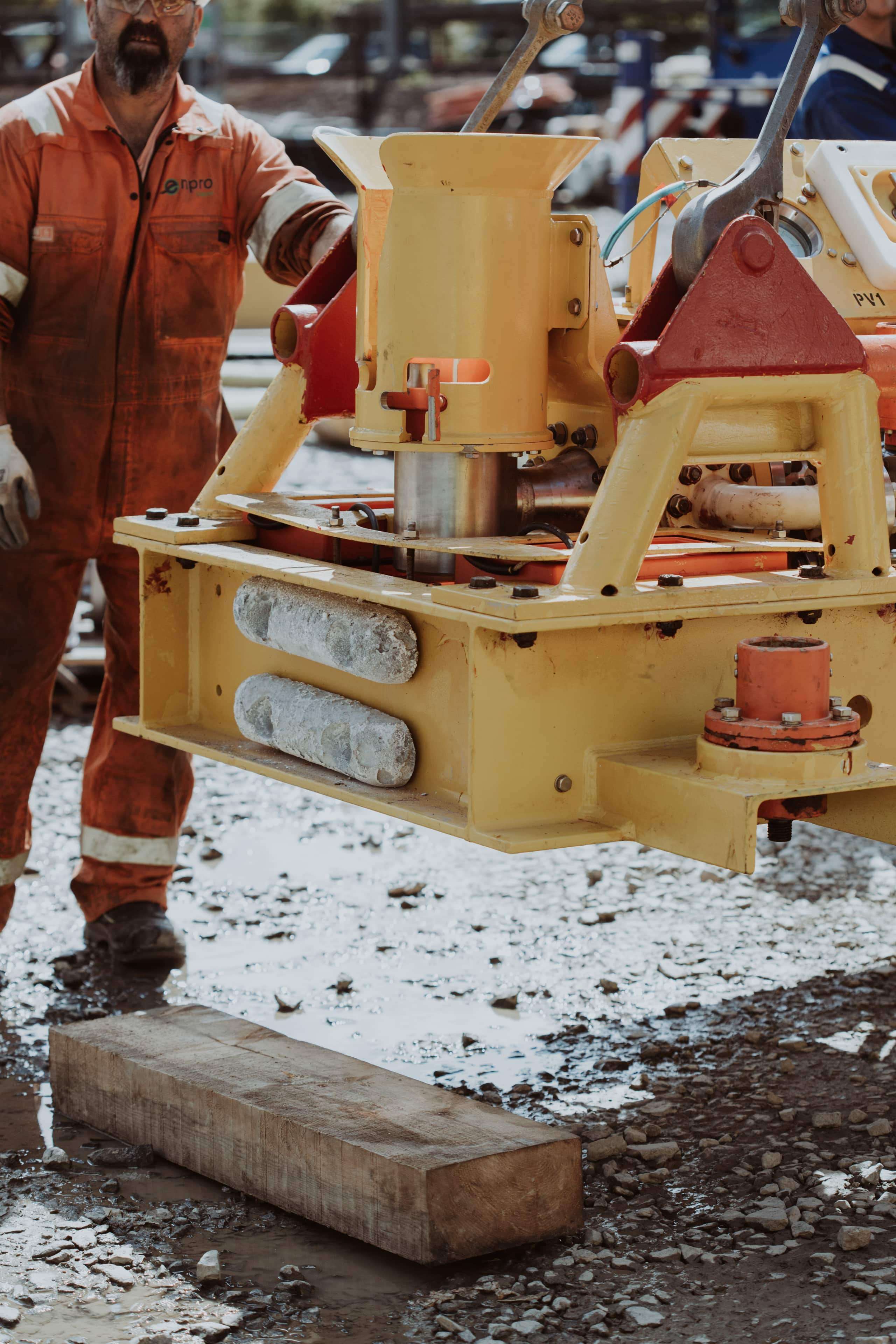 Person in PPE working on subsea tool in a machine yard