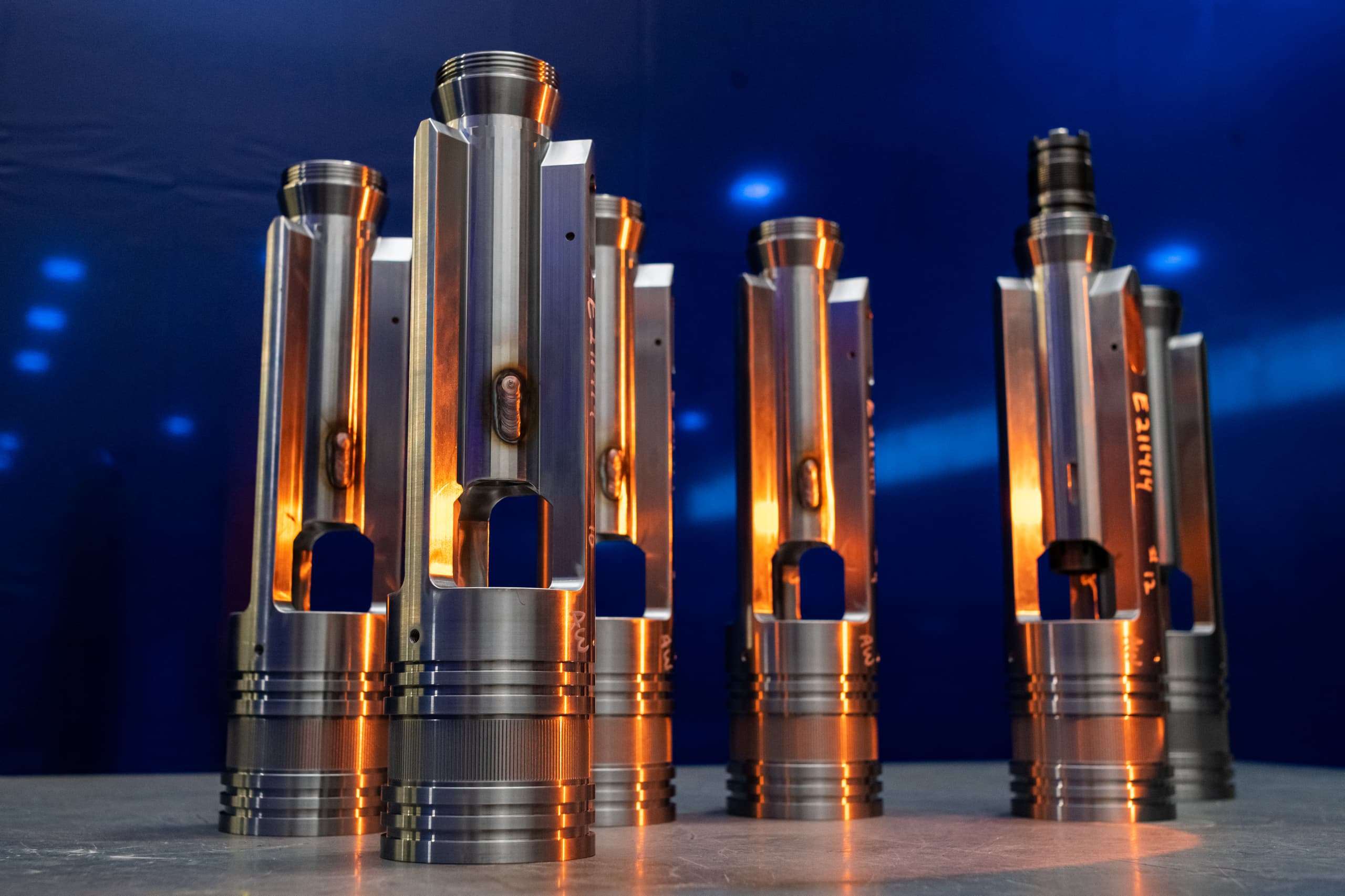 Multiple metal tools standing on table with blue background and orange light