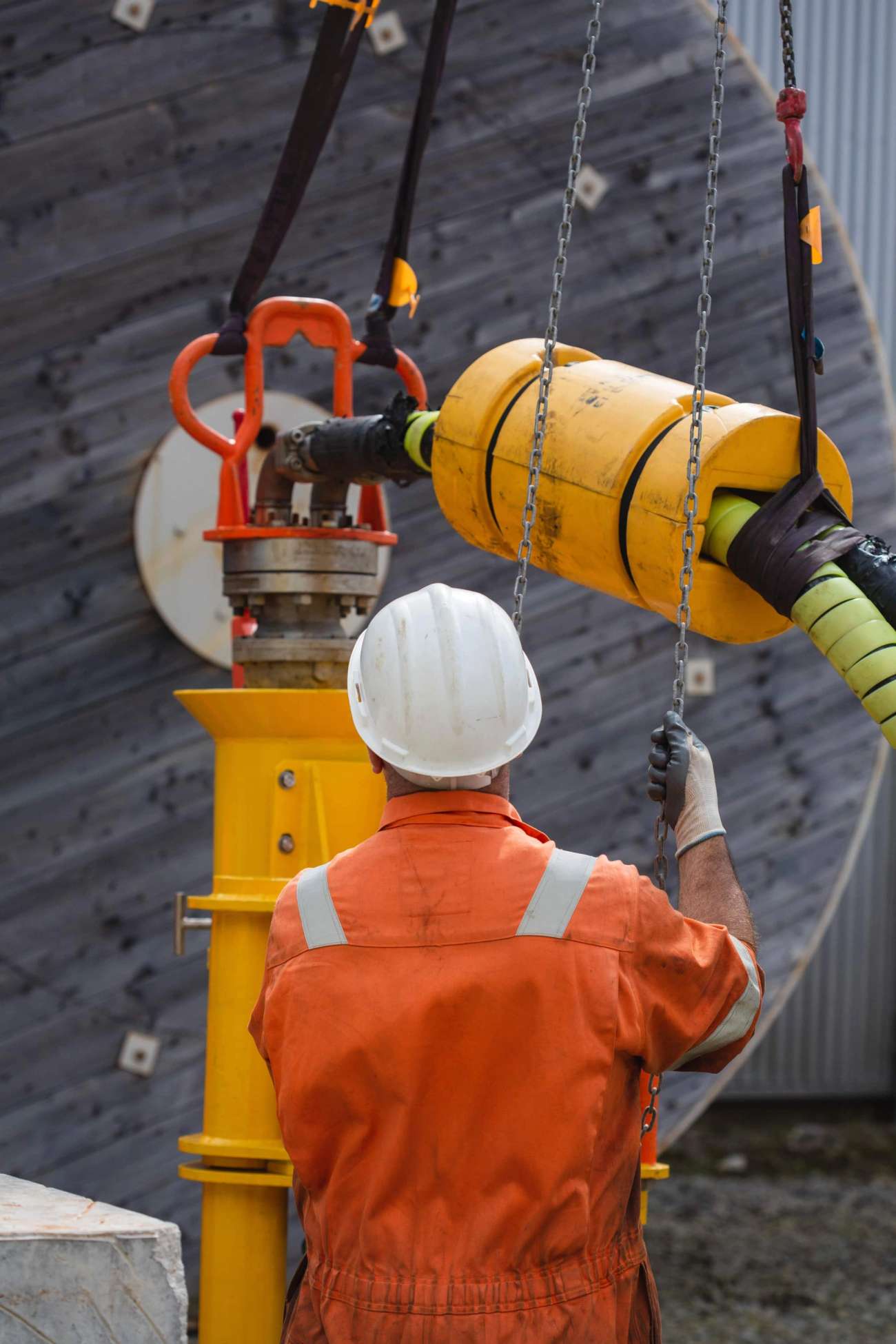 Person in boiler suit operating machinery in yard