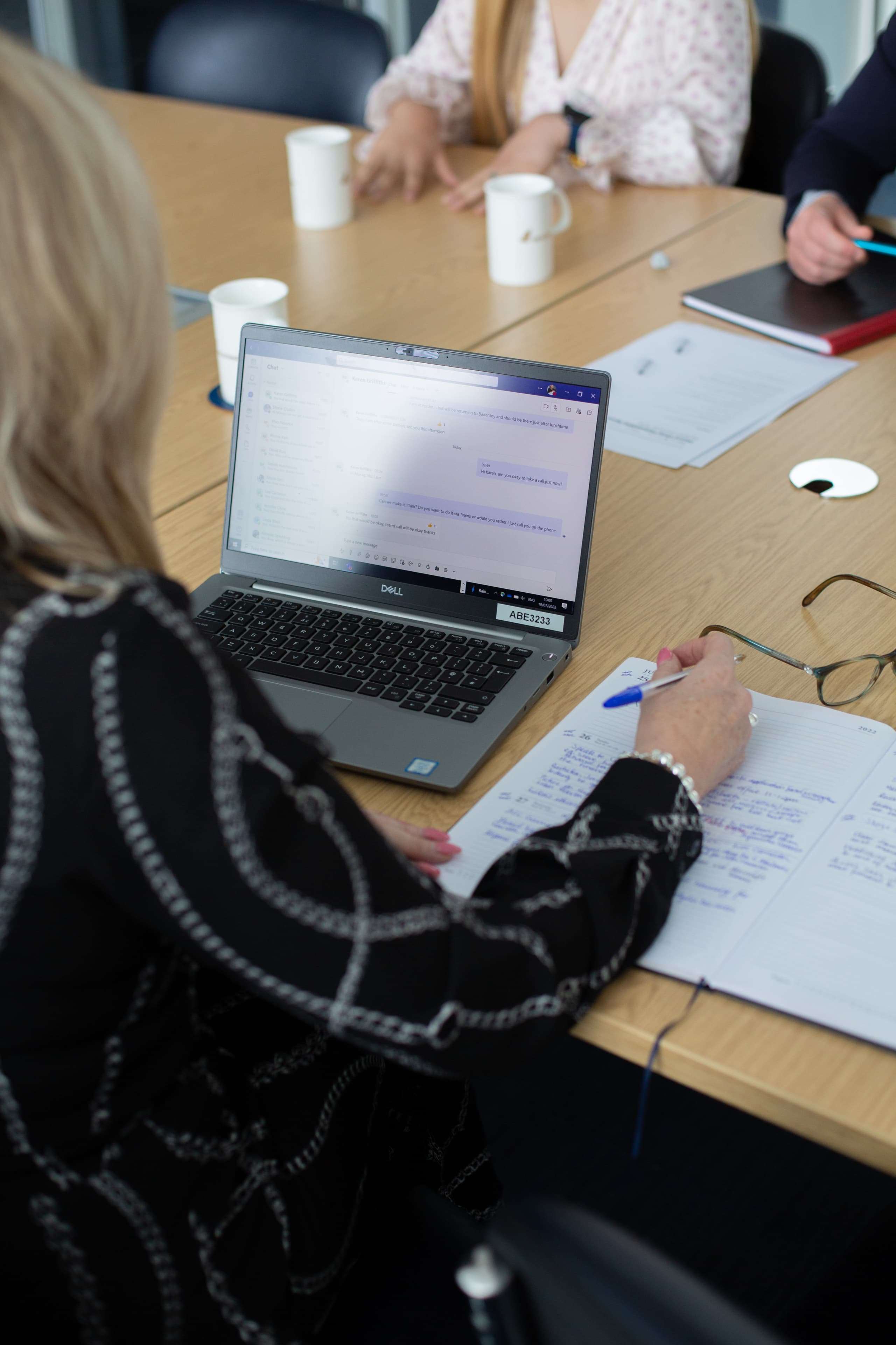 Person sitting on laptop taking notes