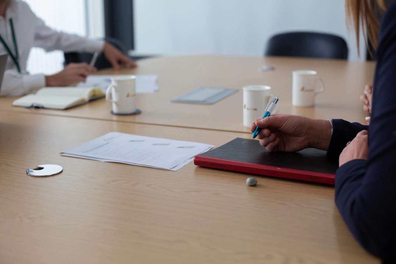 Person holding pen over notebook