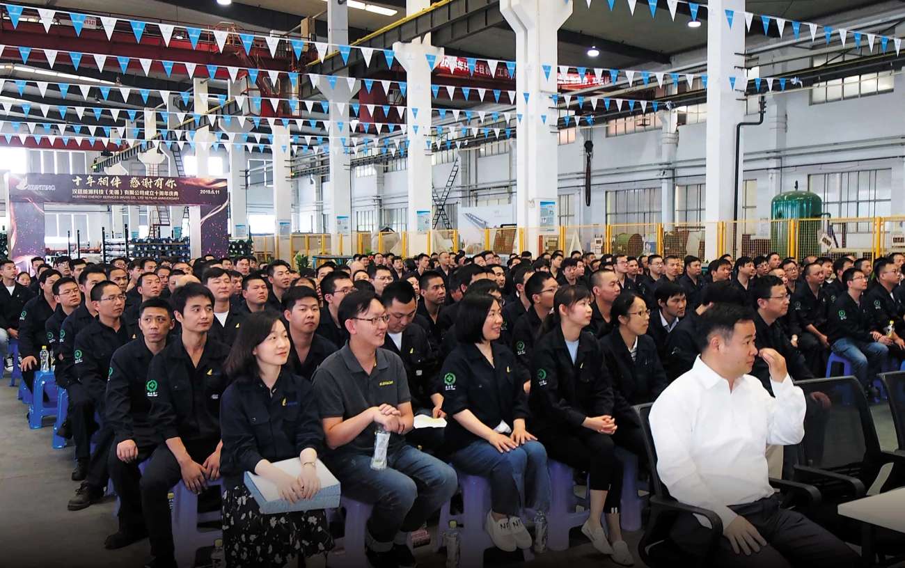 Event with large group of people sitting on chairs facing towards a stage