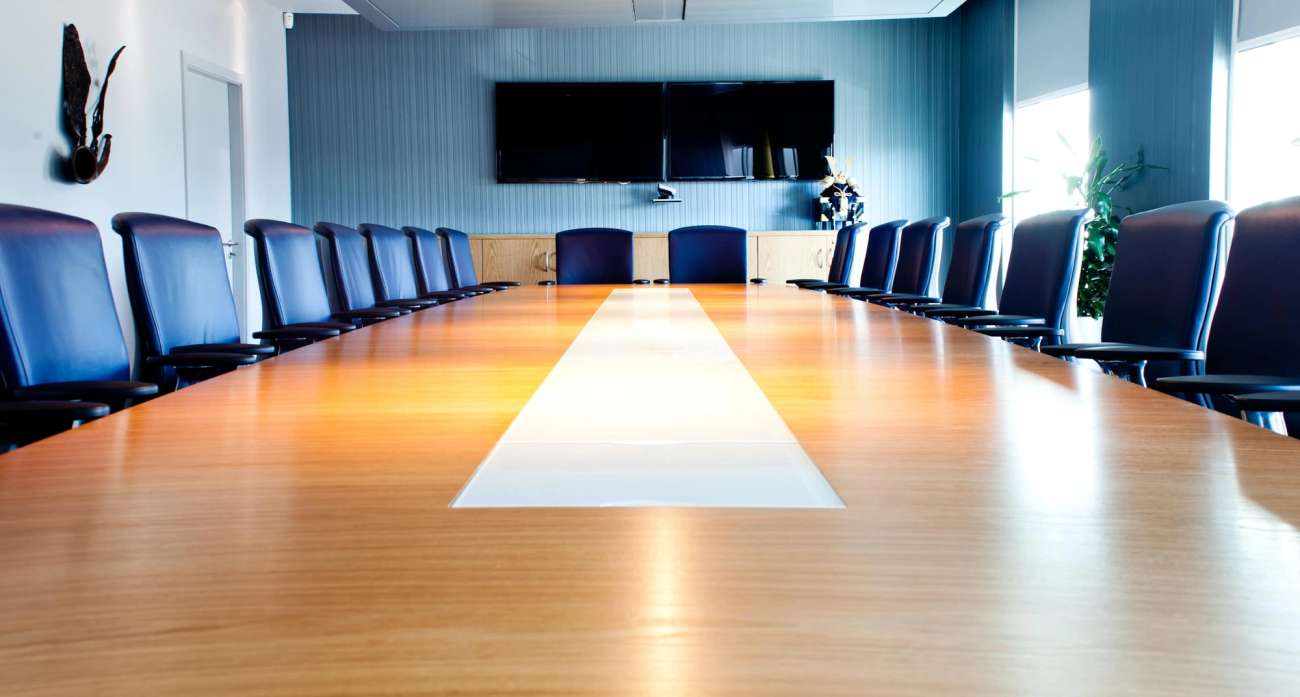 Table at board room with empty chairs