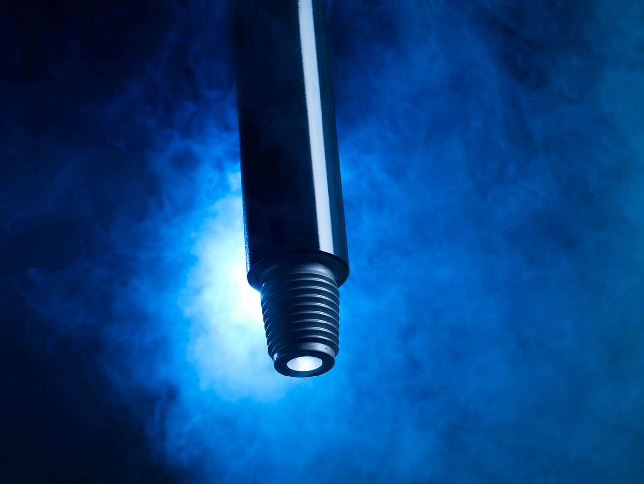 Tube with thread on blue background with smoke