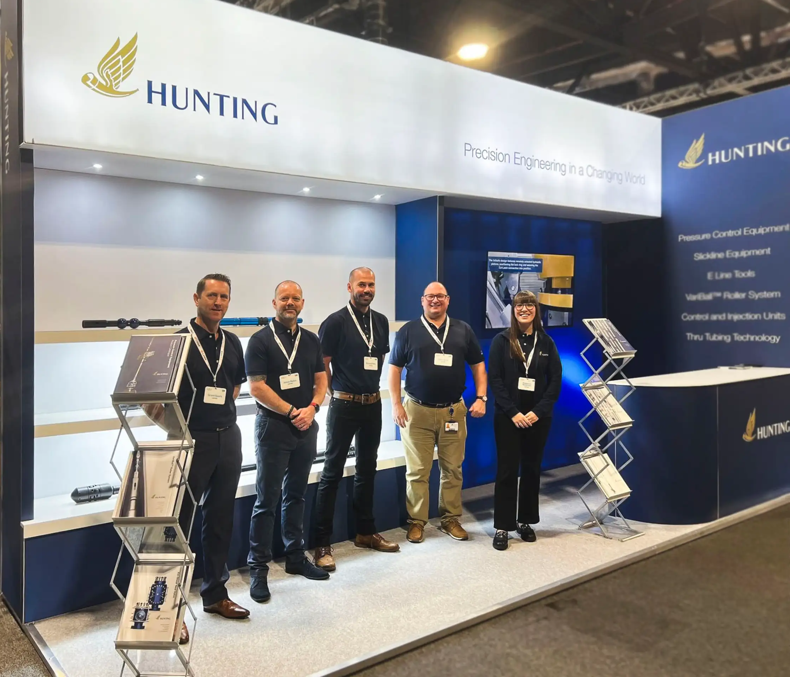 Hunting exhibition stand with 5 people standing besides each other smiling towards the camera
